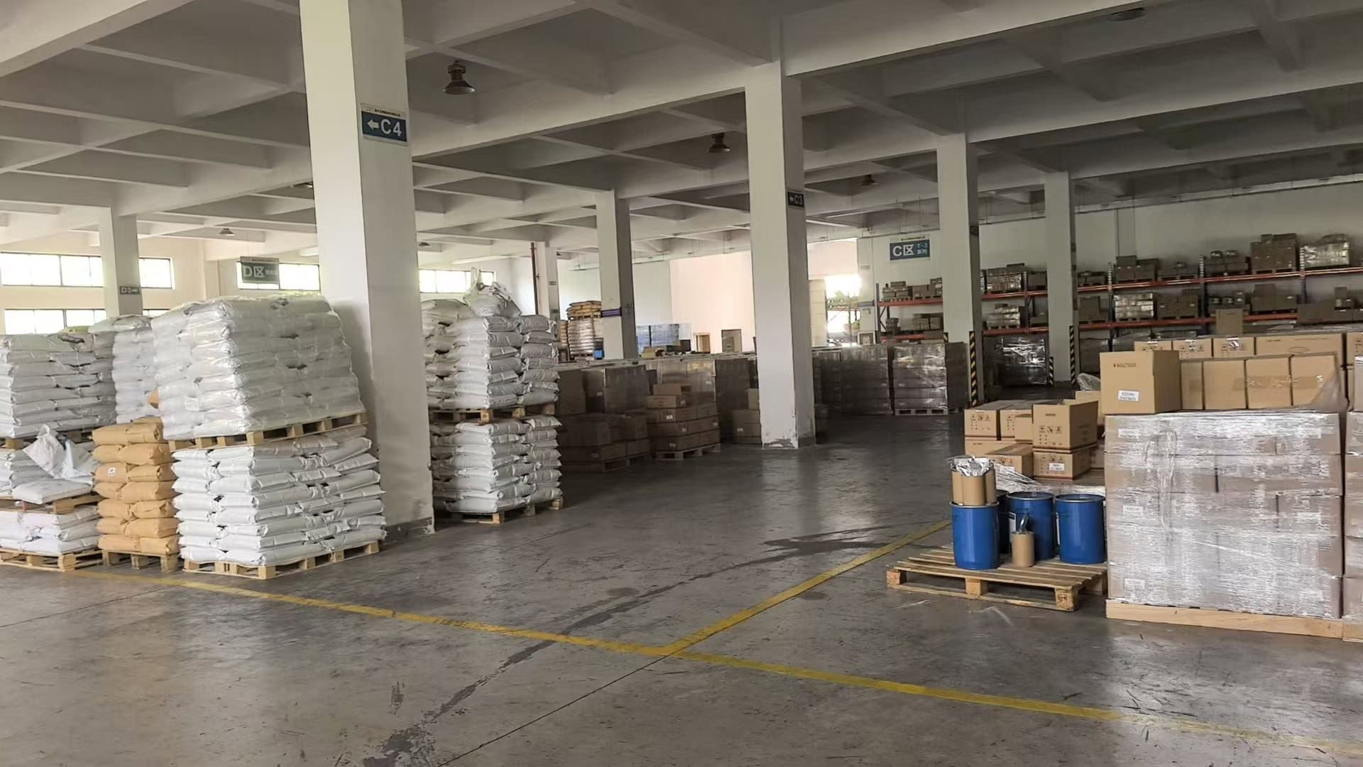 Warehouse storage area filled with large quantities of EVA hot melt adhesive products stacked on pallets.
