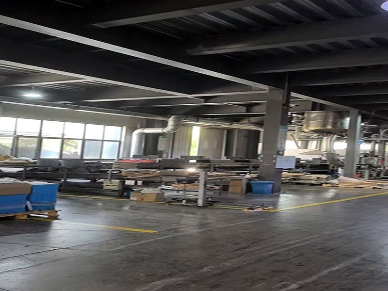 Close-up view of EVA hot melt adhesive production equipment, highlighting conveyor belts and machinery components in an industrial setting.